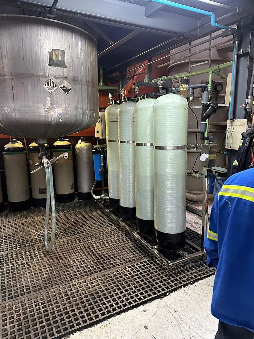 Colunas de troca iônica da Purify montadas sobre piso de grade em uma instalação industrial.