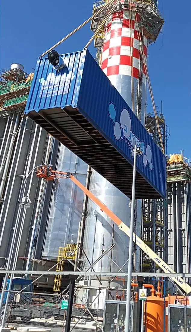 Contêiner da Purify sendo içado em uma planta industrial.