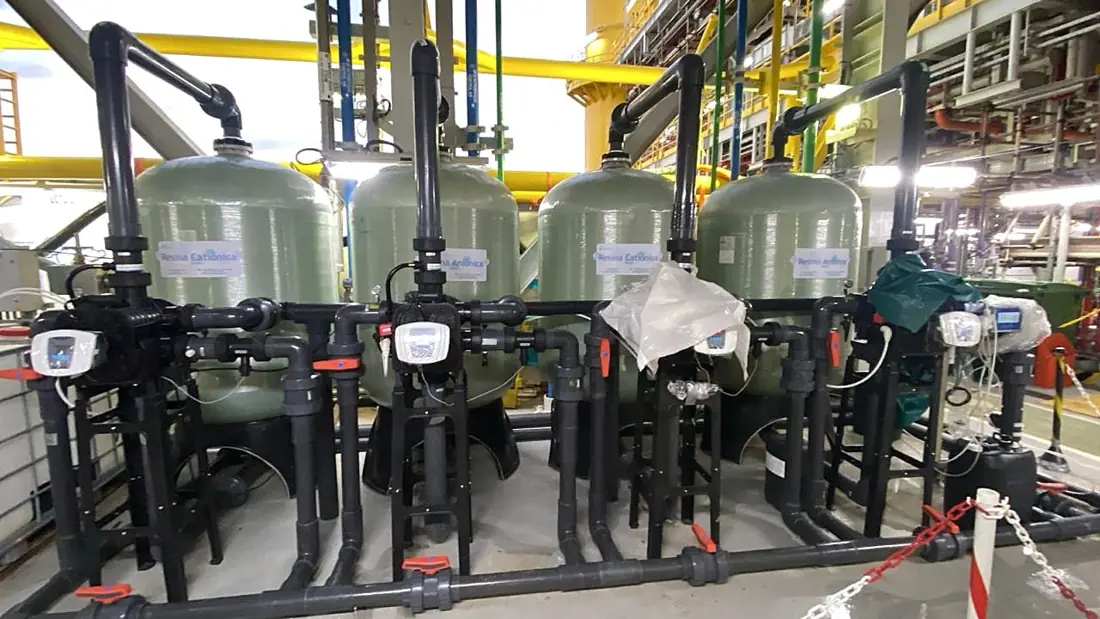 Desmineralizador industrial com colunas de resina catiônica e aniônica.